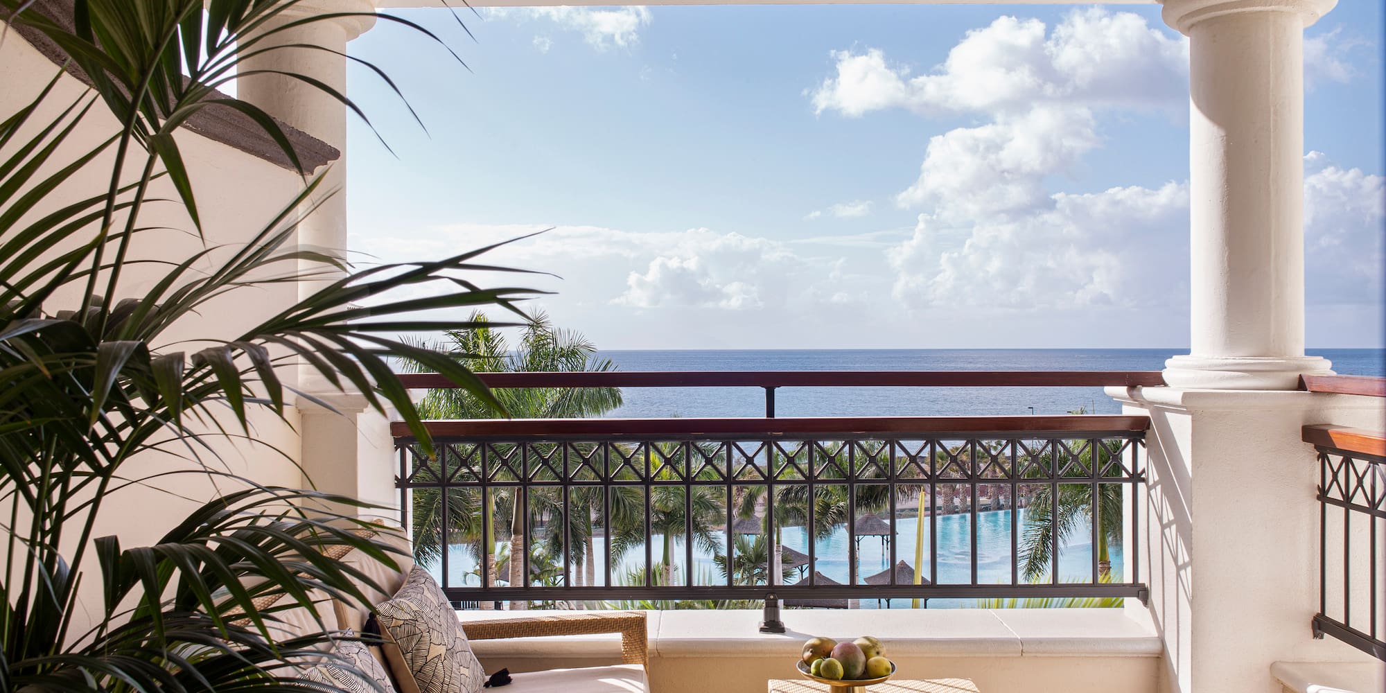 a balcony with a view of the ocean and a couch and a table