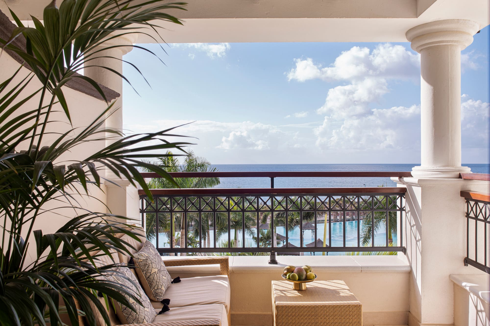 a balcony with a view of the ocean and a couch and a table