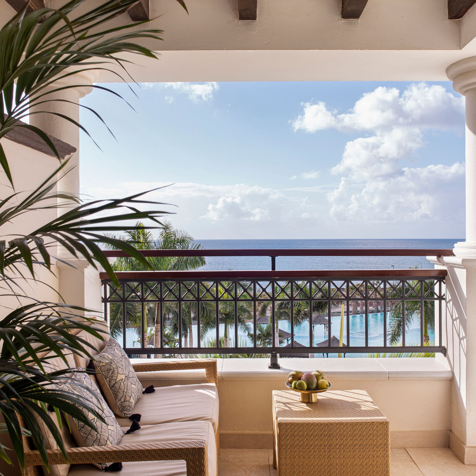 a balcony with a view of the ocean and a couch and a table