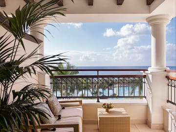 a balcony with a view of the ocean and a couch and a table