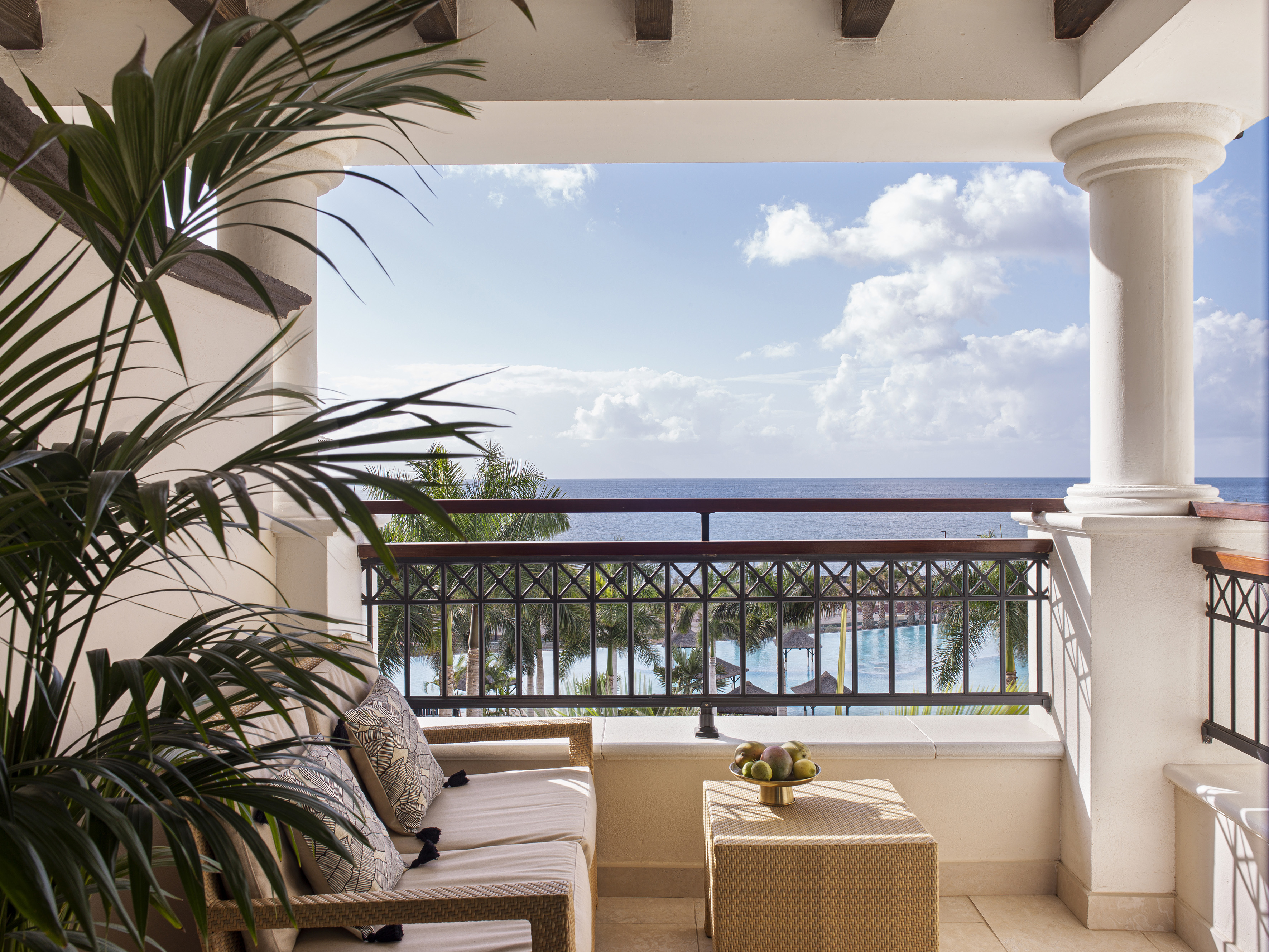 a balcony with a view of the ocean and a couch and a table