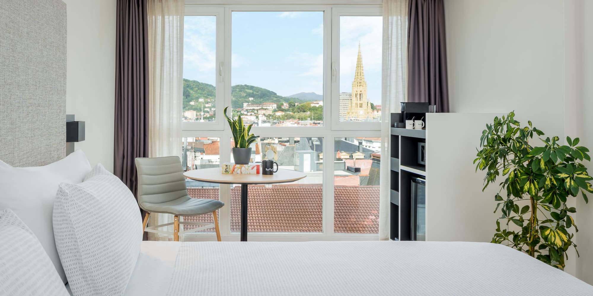 a room with a bed and a table and chairs