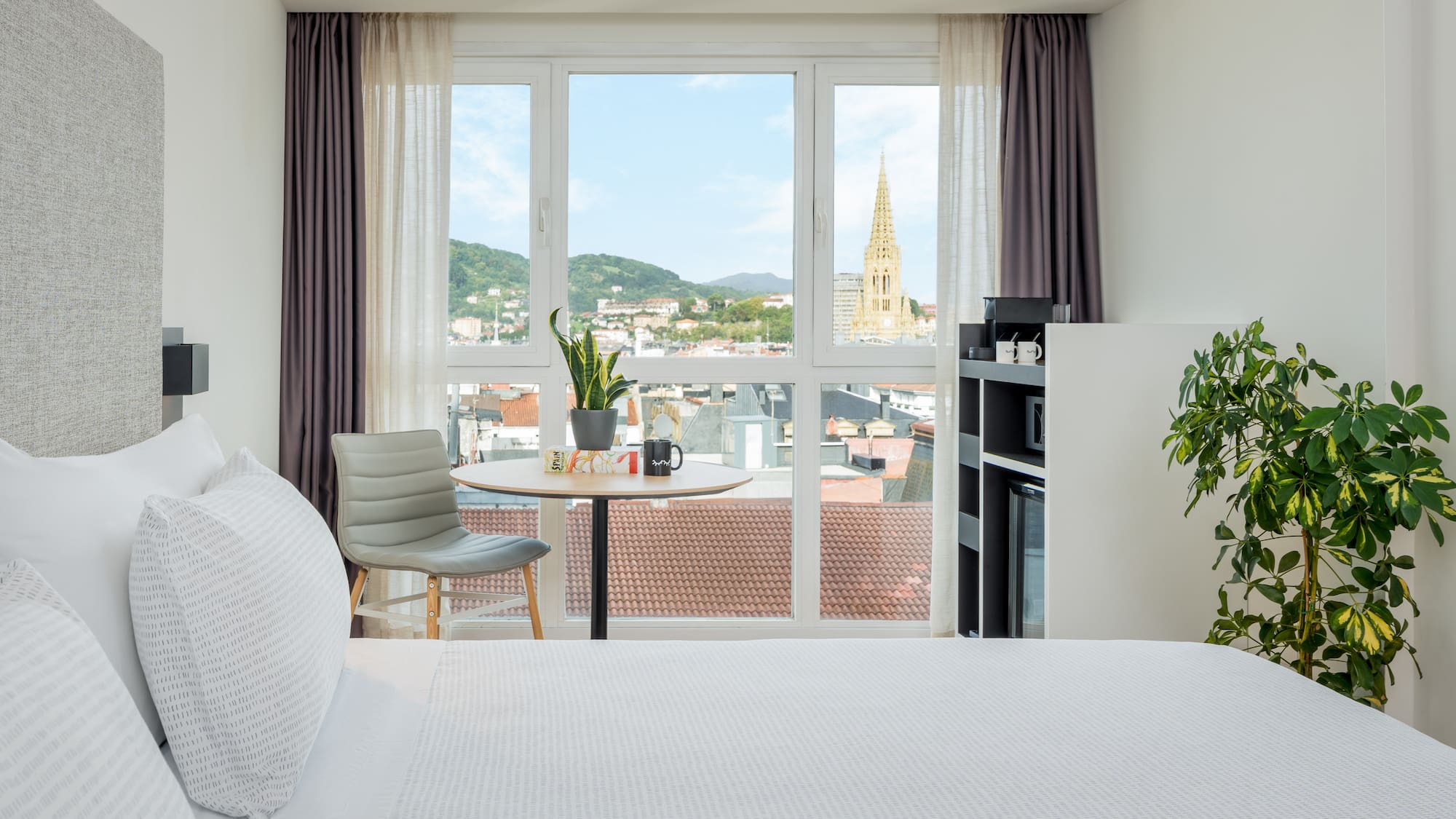 a room with a bed and a table and chairs