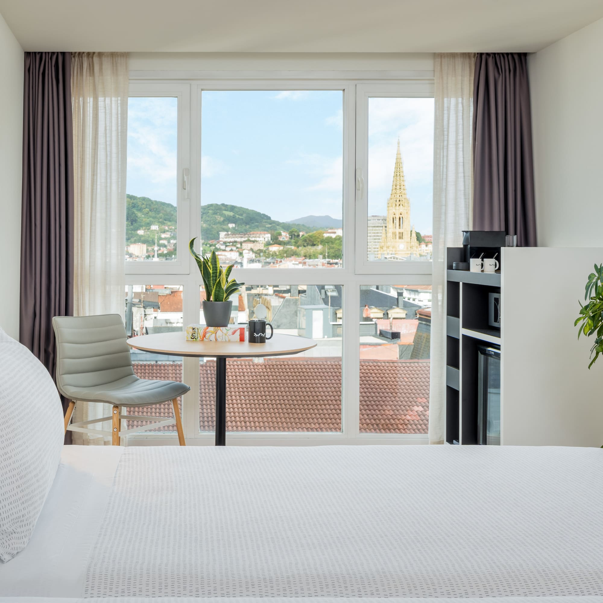 a room with a bed and a table and chairs