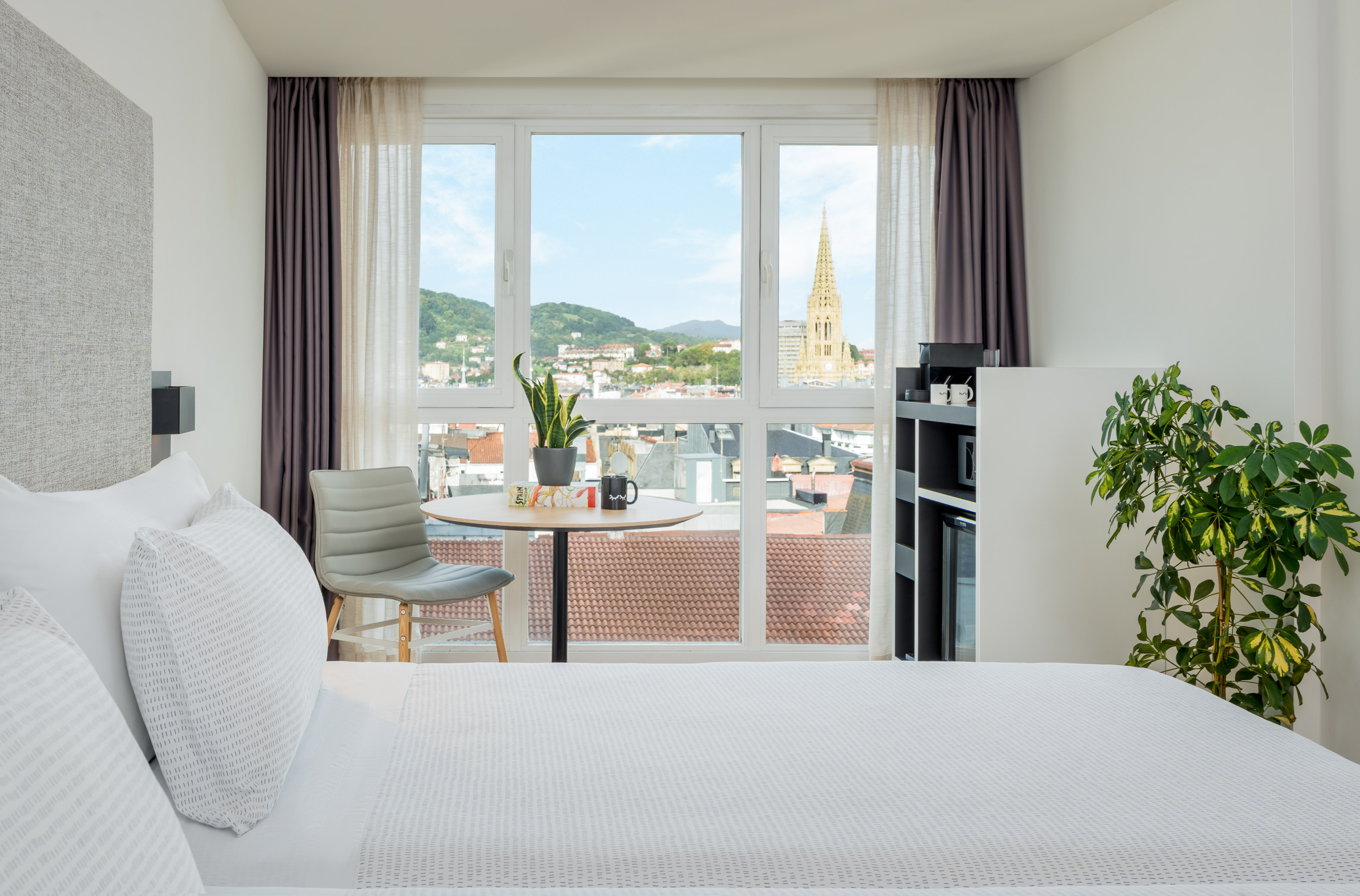 a room with a bed and a table and chairs