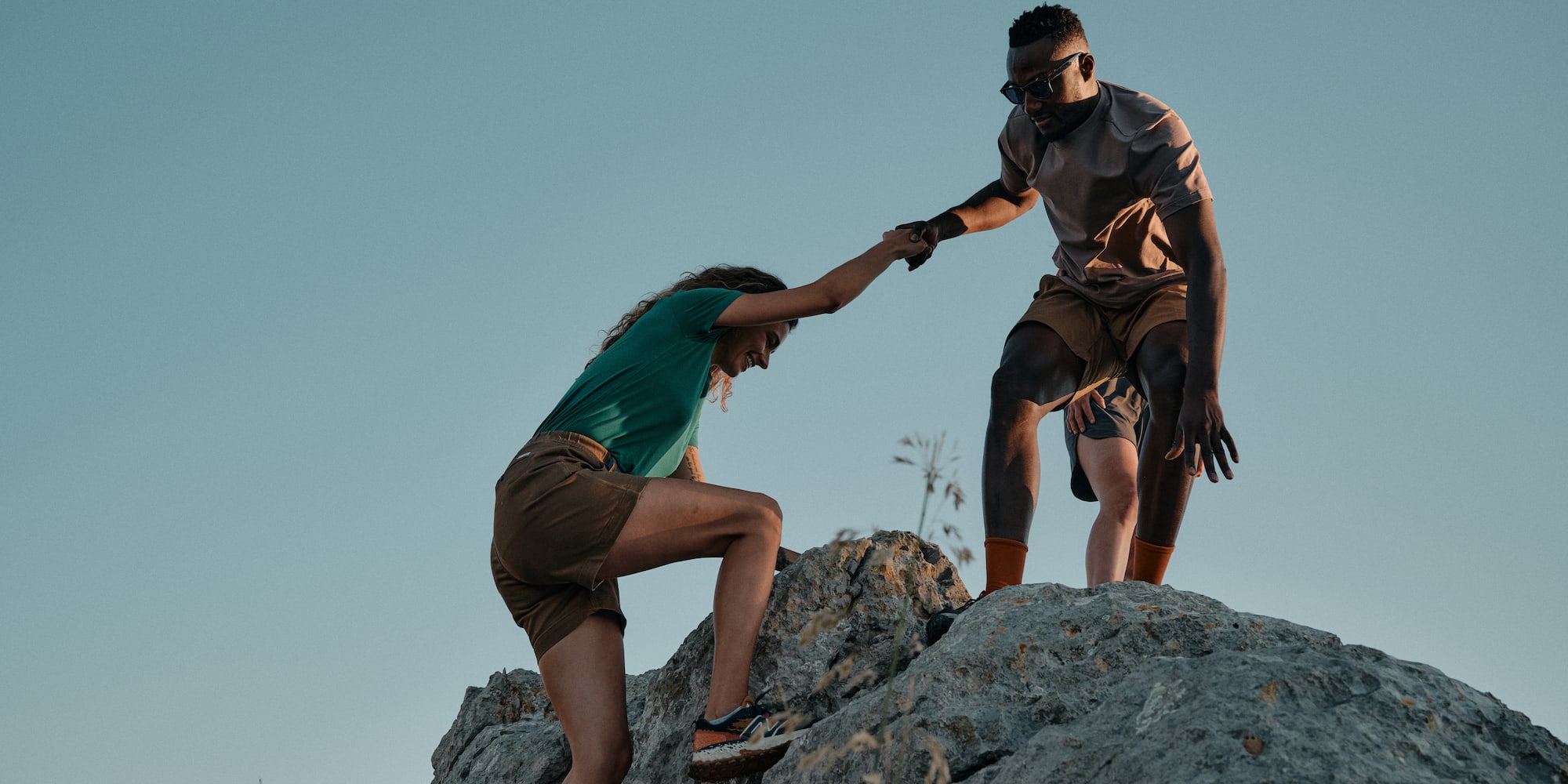 a man and woman climbing a rock