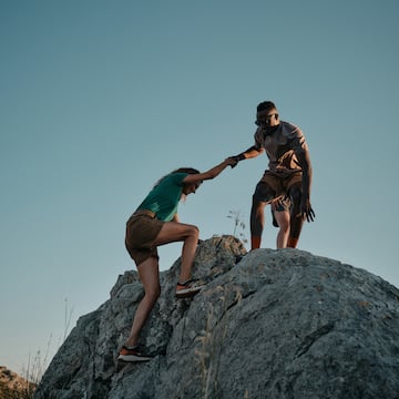 a man and woman climbing a rock