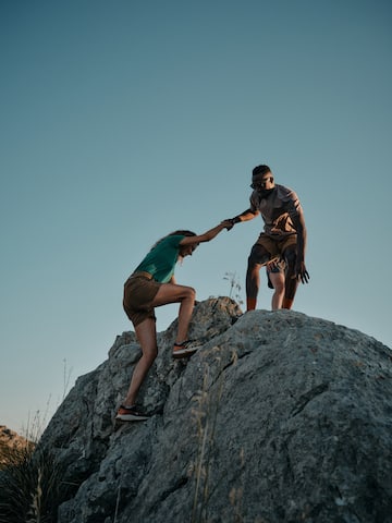 a man and woman climbing a rock