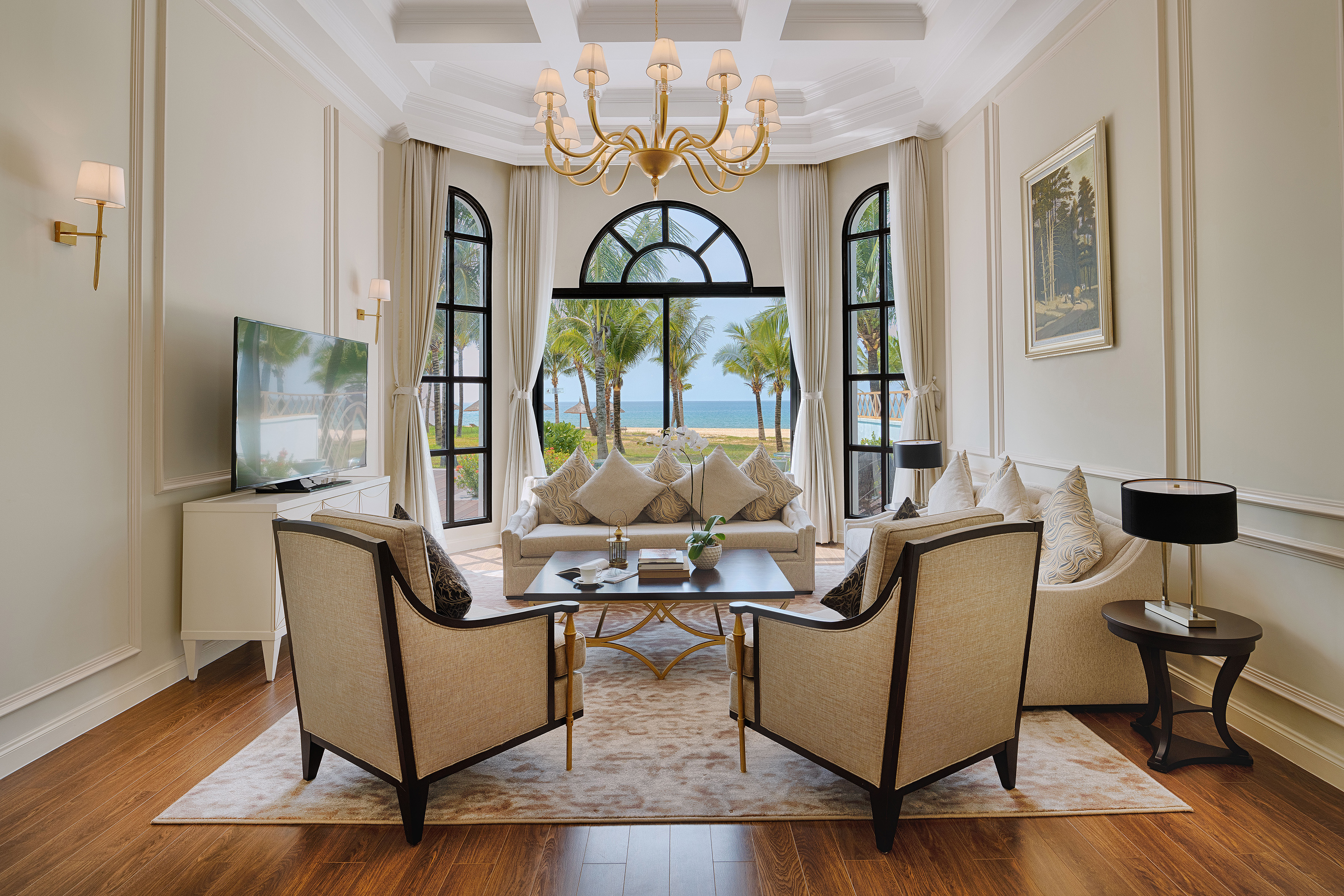 Elegant living room in a luxury suite overlooking a tropical beach and ocean.