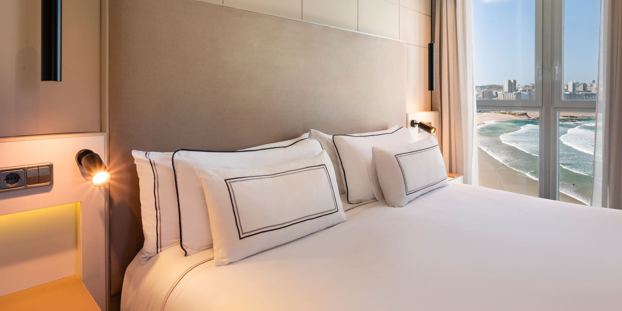 a bed with white sheets and pillows