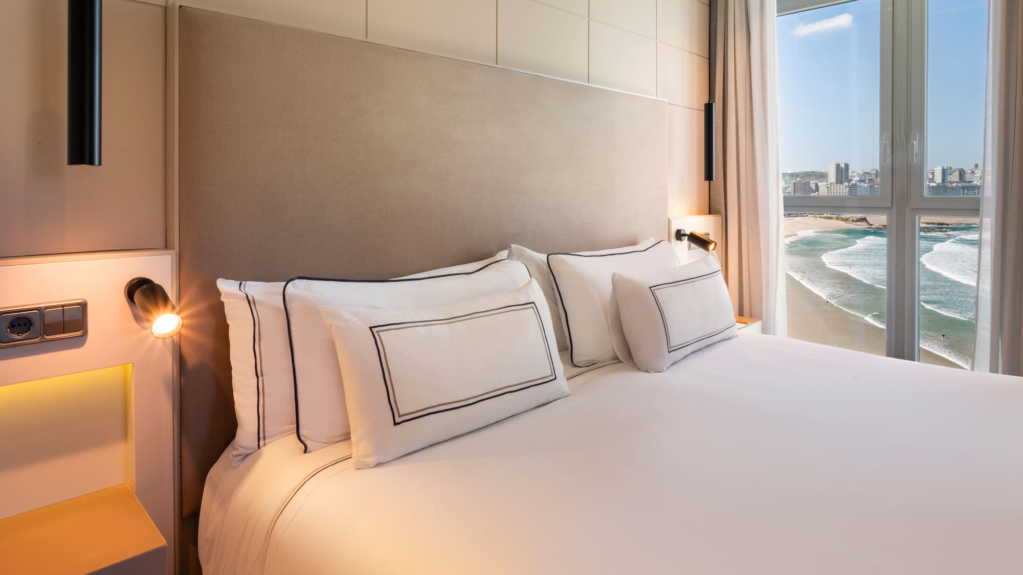 a bed with white sheets and pillows