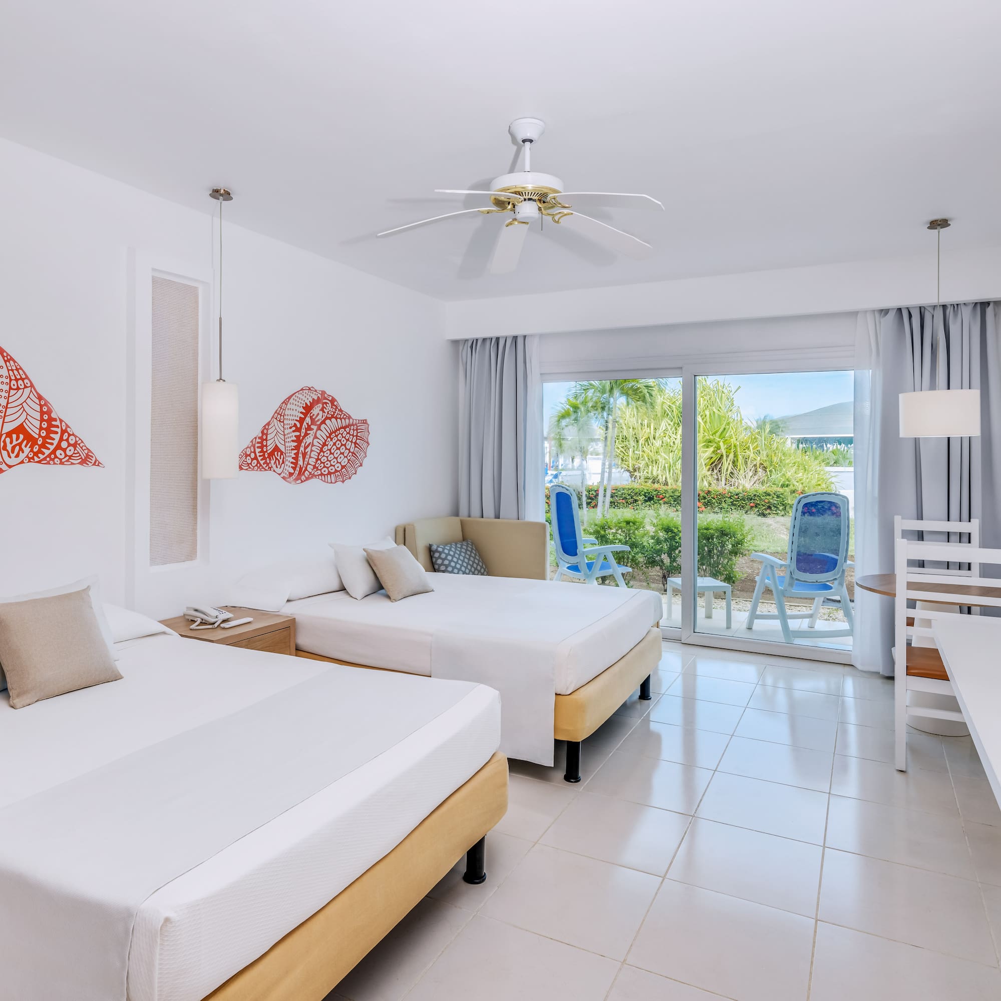 a room with two beds and a ceiling fan