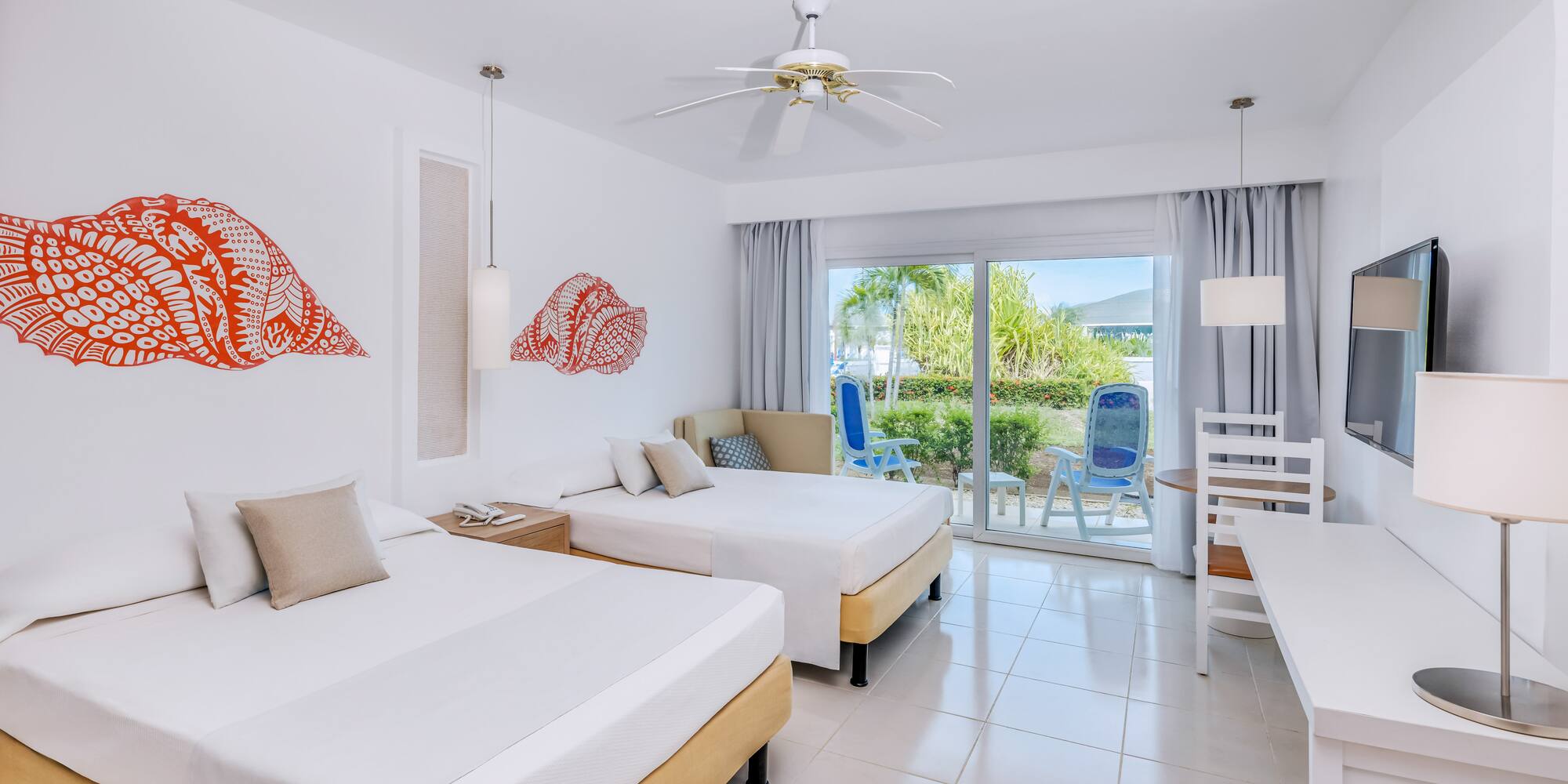 a room with two beds and a ceiling fan