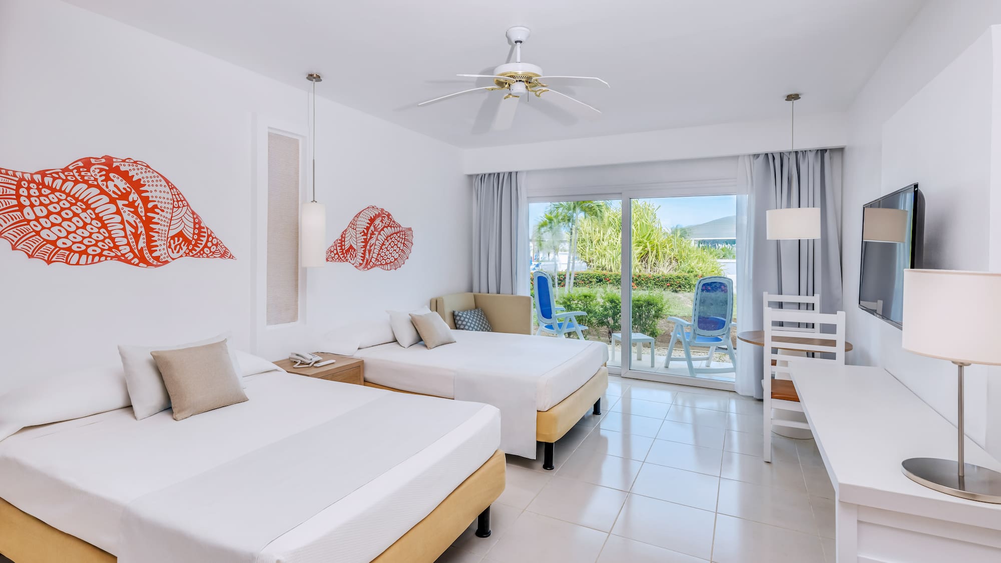 a room with two beds and a ceiling fan