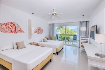 a room with two beds and a ceiling fan