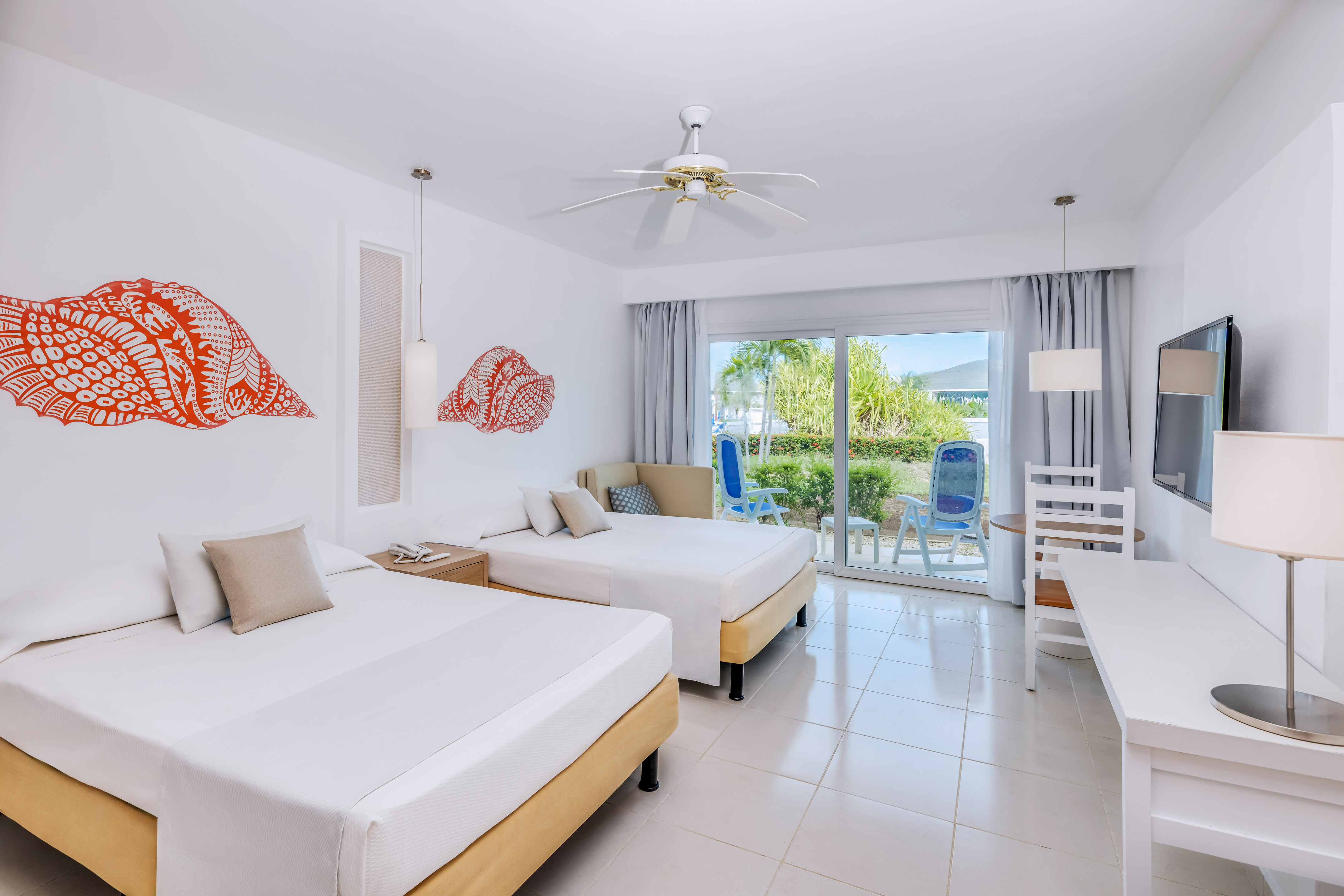 a room with two beds and a ceiling fan