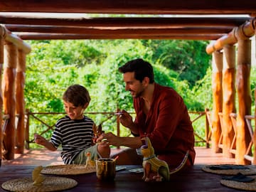 a man and child sitting at a table with toys