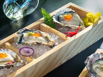 a wooden box with oysters and vegetables