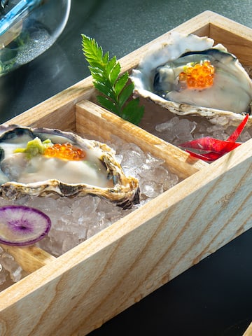 a wooden box with oysters and vegetables