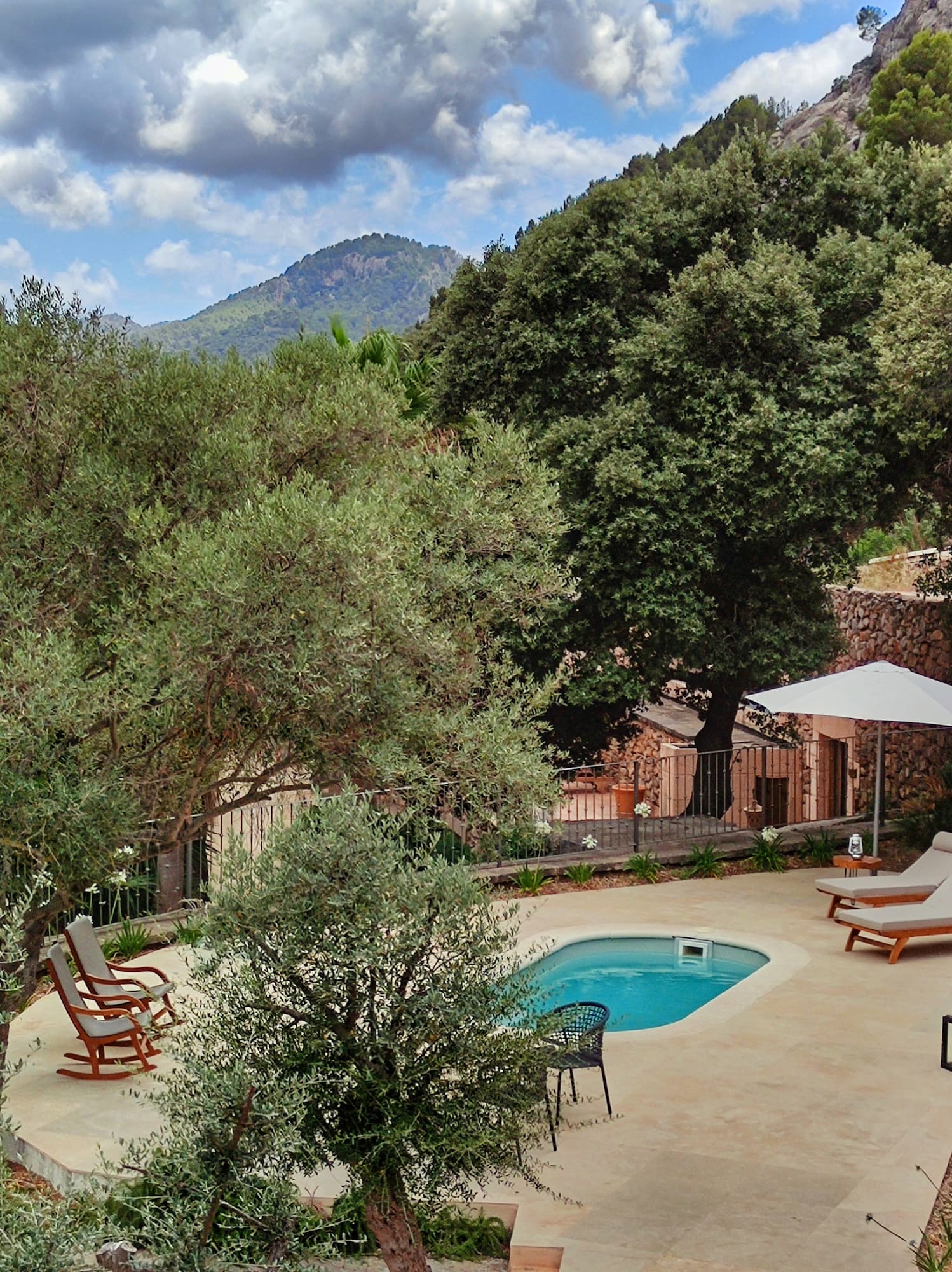 a pool with chairs and a umbrella in a backyard