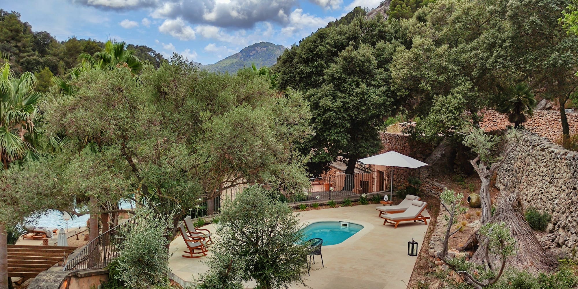 a pool with chairs and a umbrella in a backyard