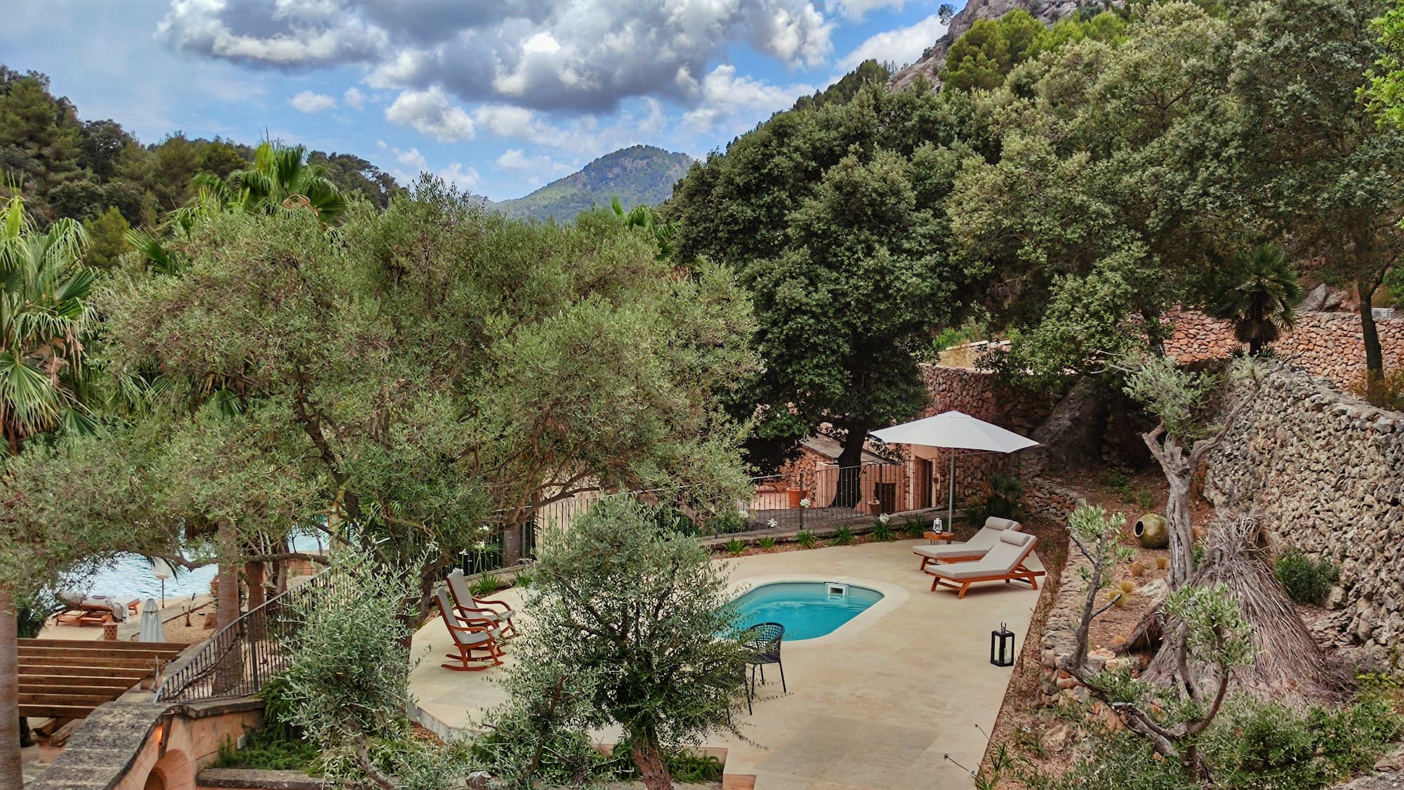 a pool with chairs and a umbrella in a backyard