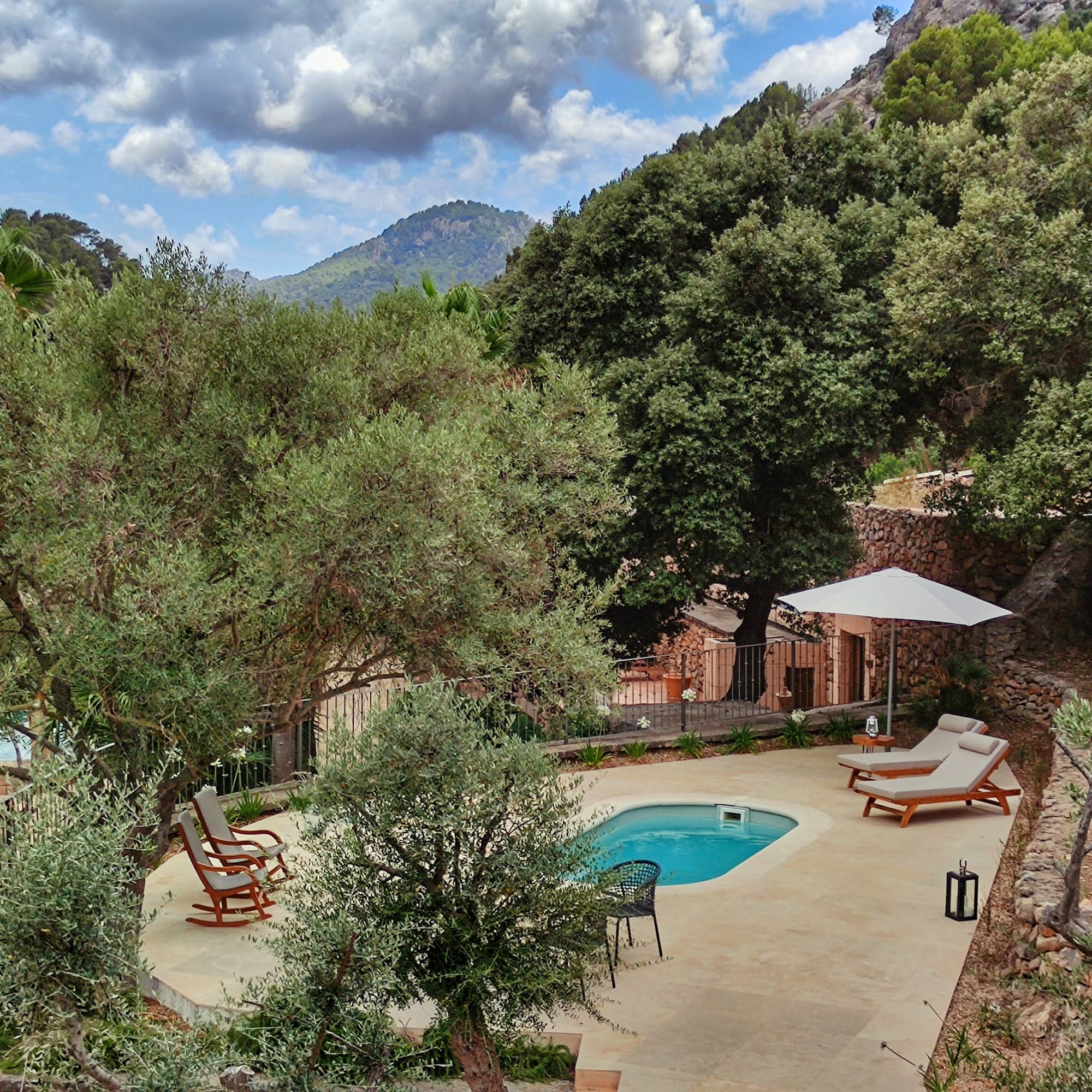 a pool with chairs and a umbrella in a backyard