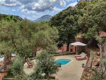 a pool with chairs and a umbrella in a backyard