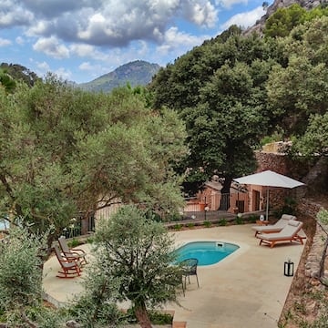 a pool with chairs and a umbrella in a backyard