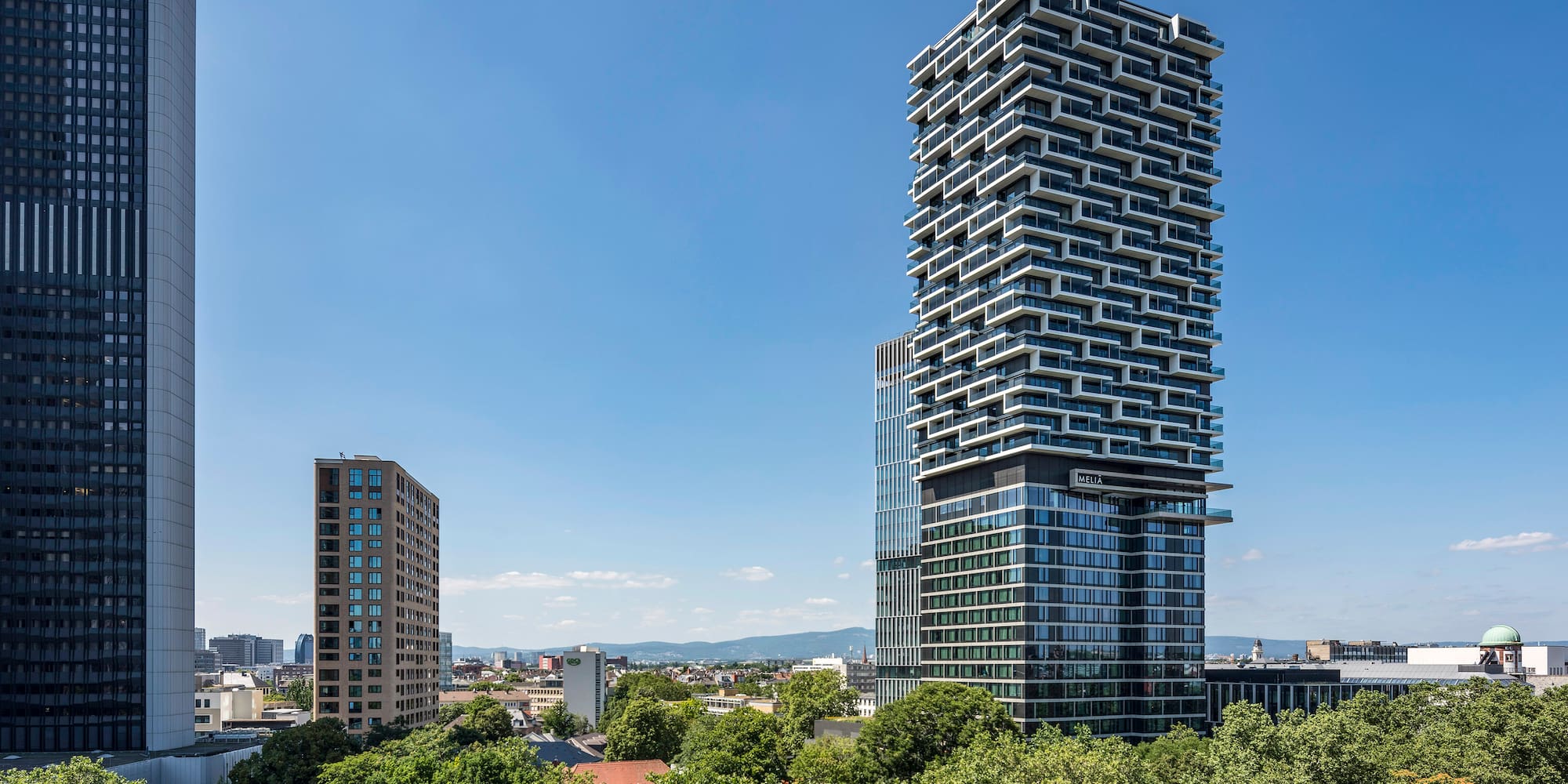 a tall buildings with trees in the background