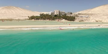 a beach with a building and trees
