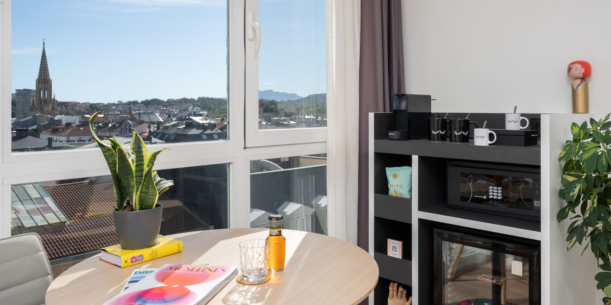 a table with a plant on it and a microwave in front of a window