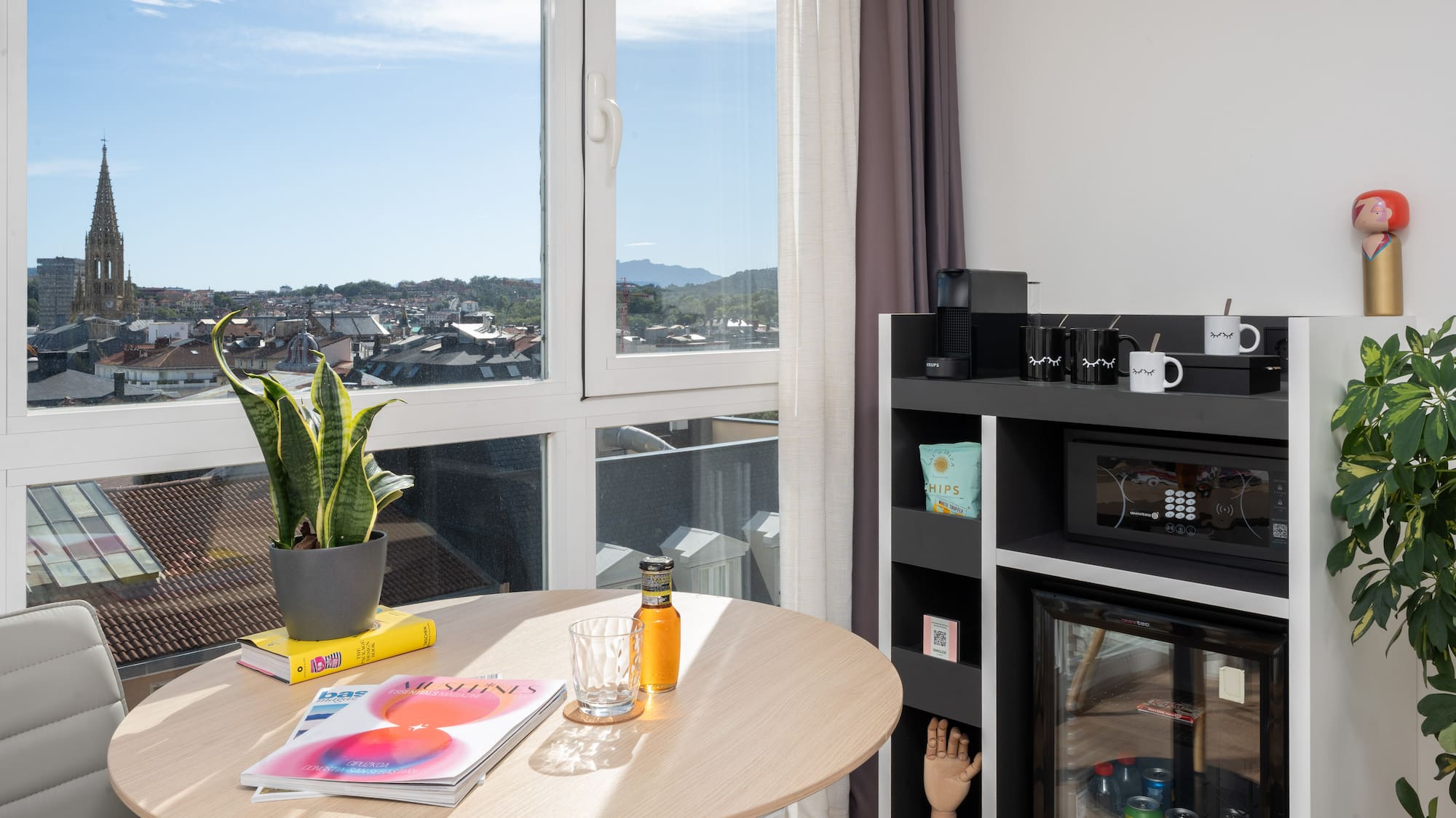 a table with a plant on it and a microwave in front of a window
