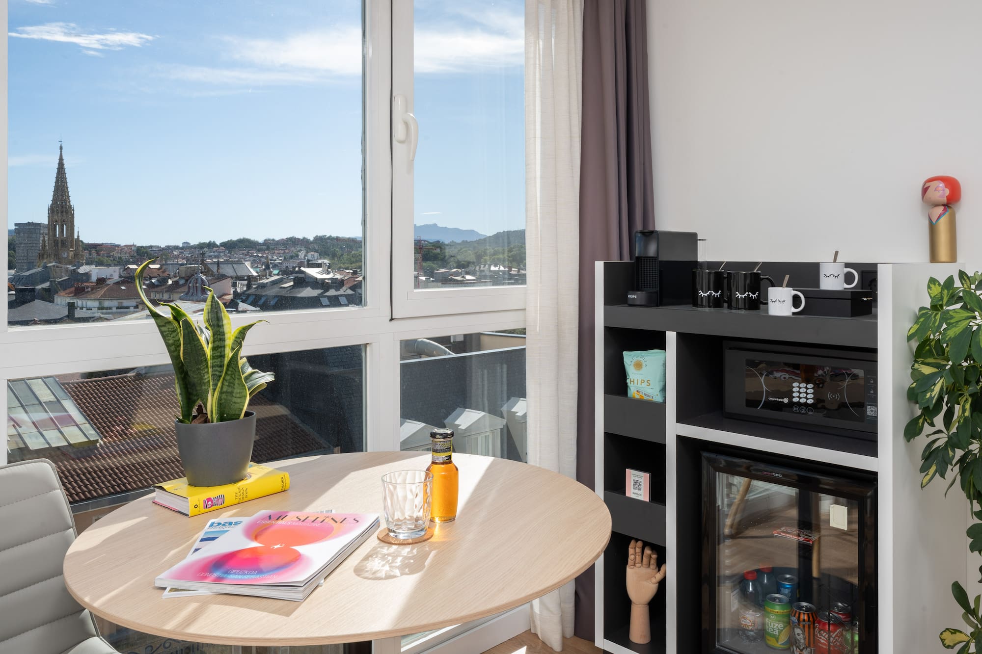 a table with a plant on it and a microwave in front of a window