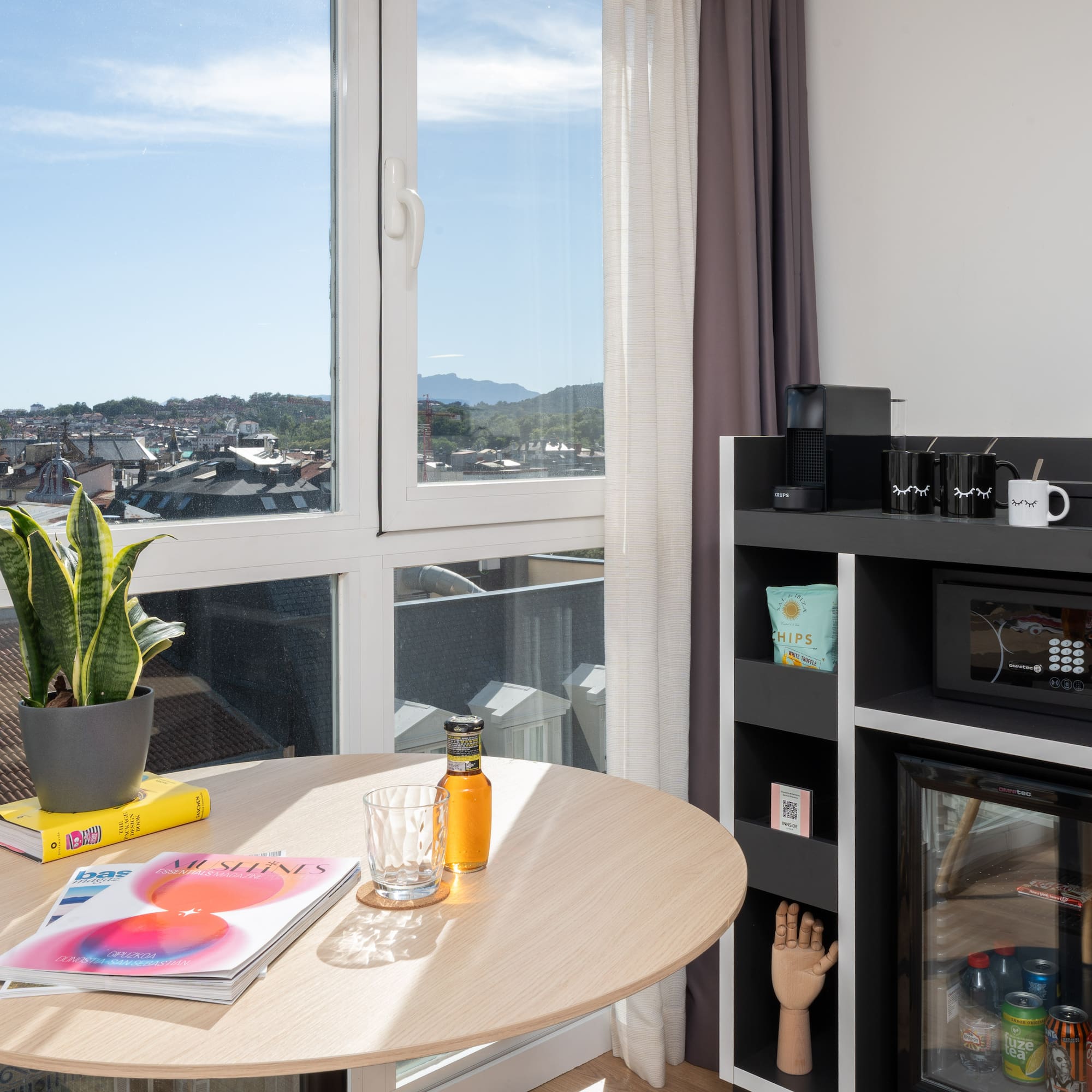 a table with a plant on it and a microwave in front of a window