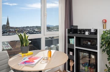 a table with a plant on it and a microwave in front of a window