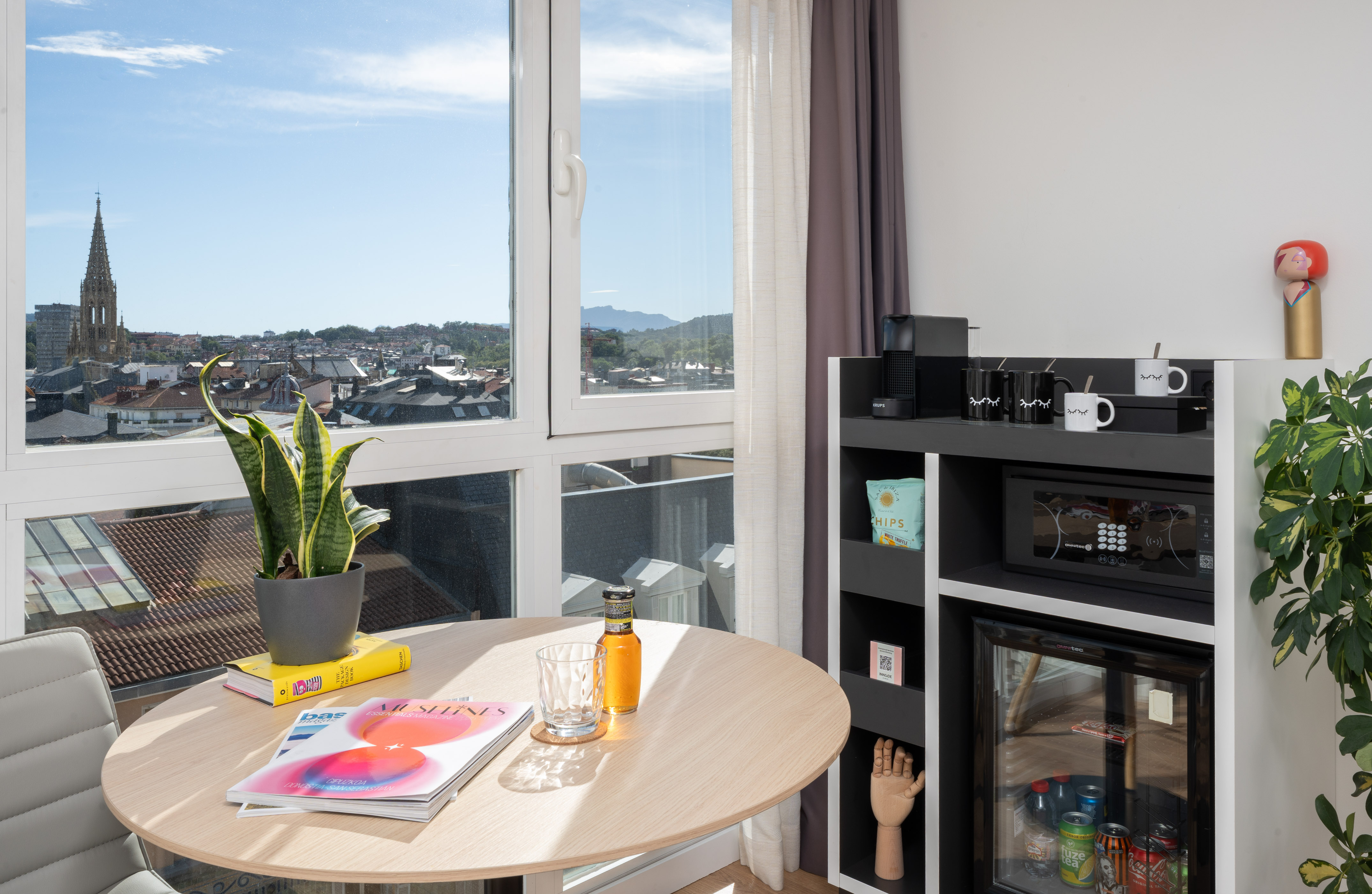 a table with a plant on it and a microwave in front of a window