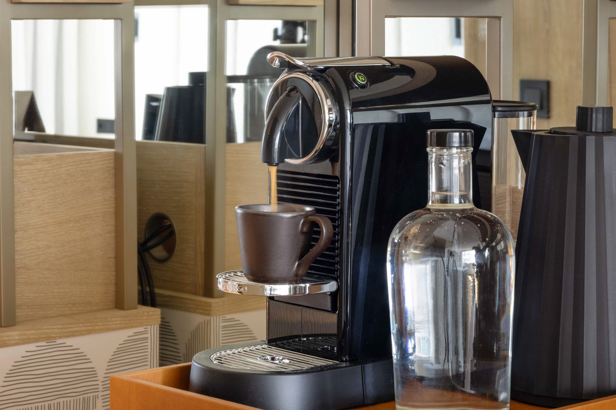 a coffee machine and a bottle on a shelf