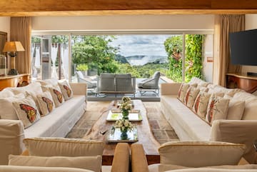 a living room with large windows and couches