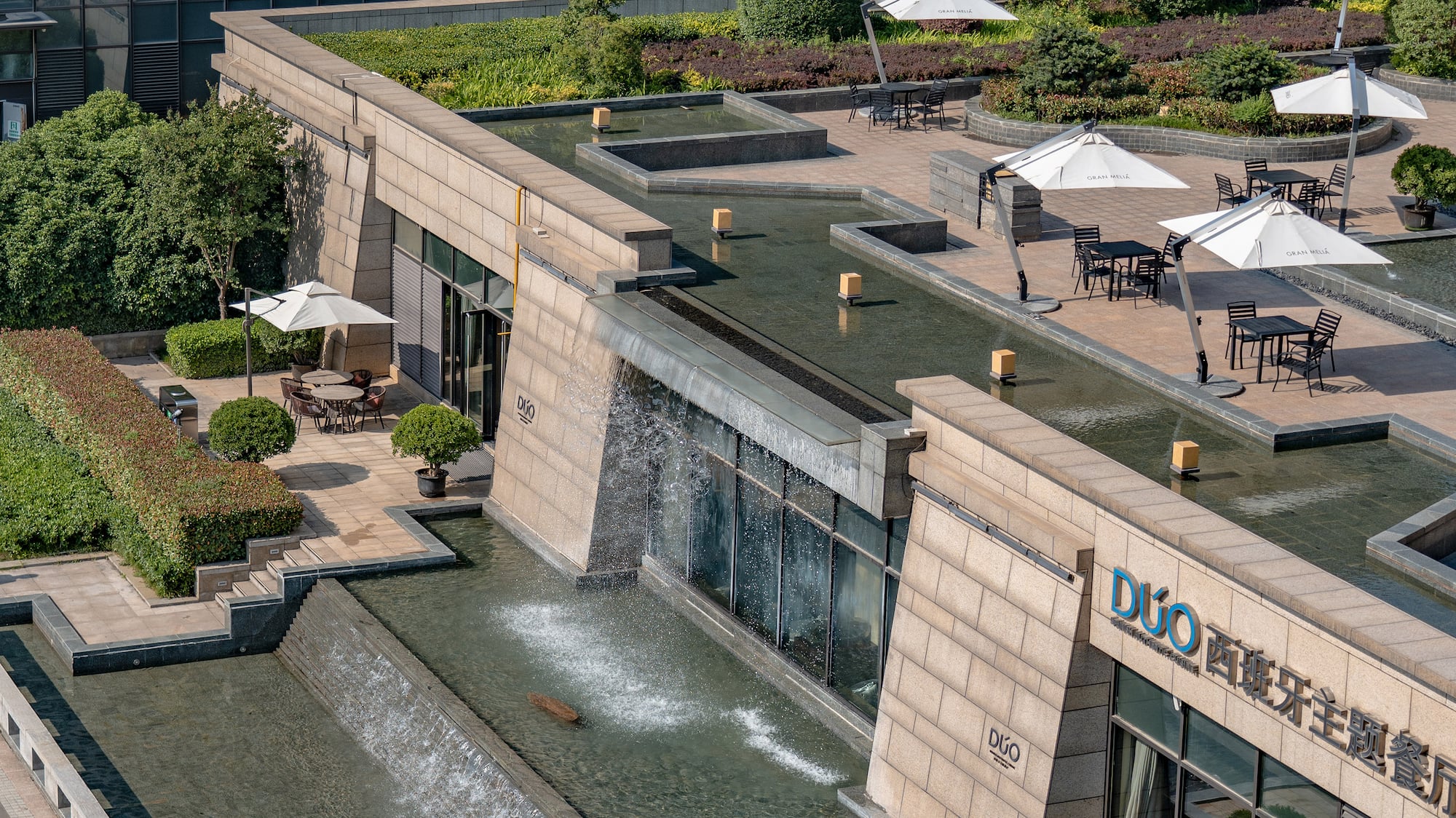 a building with a fountain and umbrellas