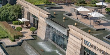 a building with a fountain and umbrellas