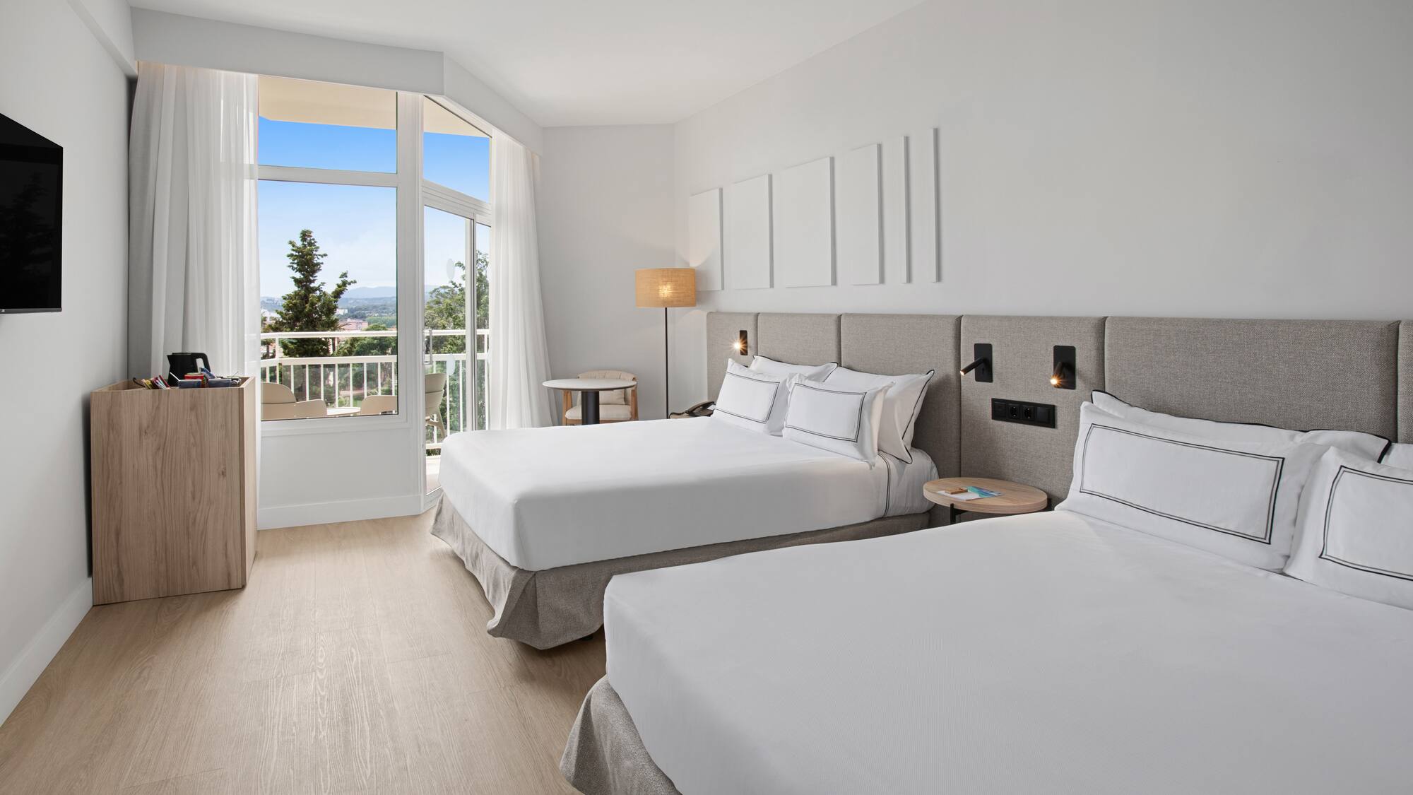 a room with two beds and a balcony