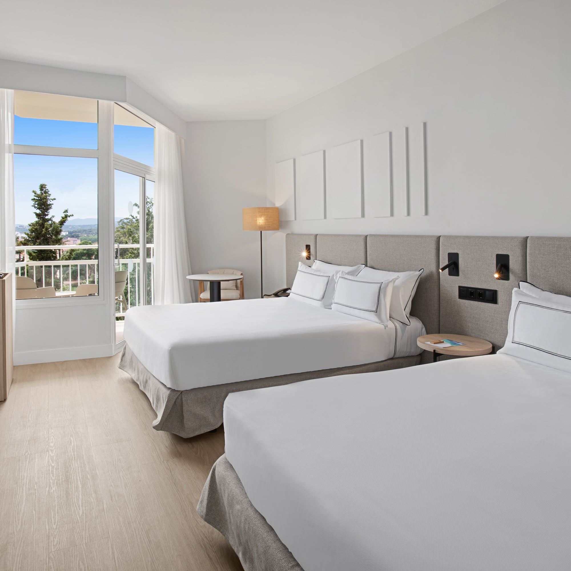 a room with two beds and a balcony