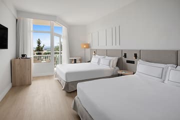 a room with two beds and a balcony