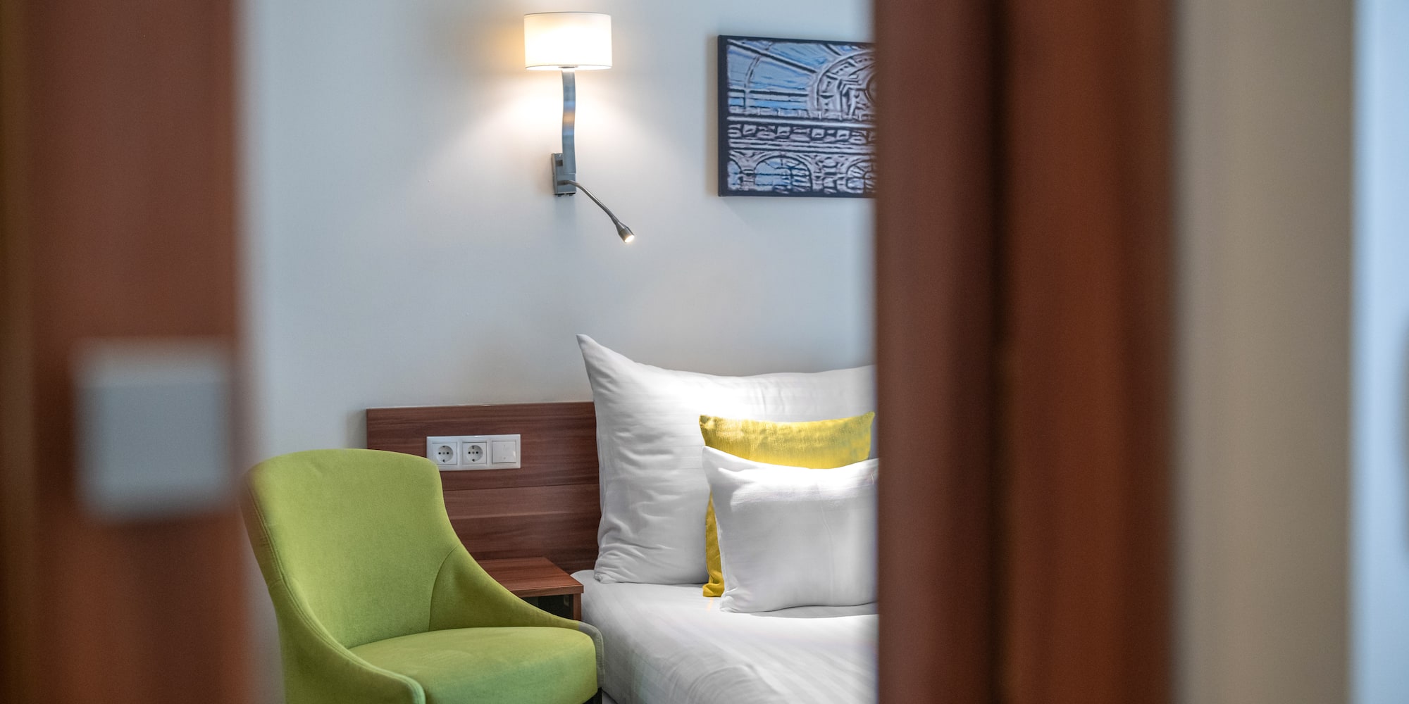 a green chair next to a bed