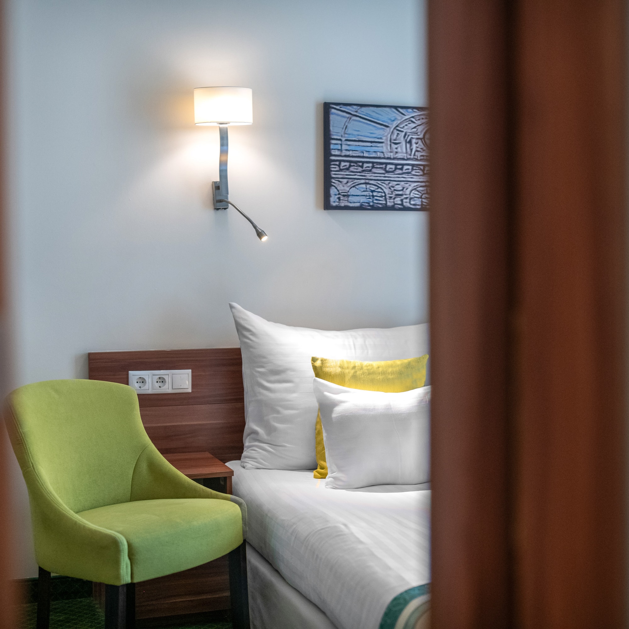 a green chair next to a bed