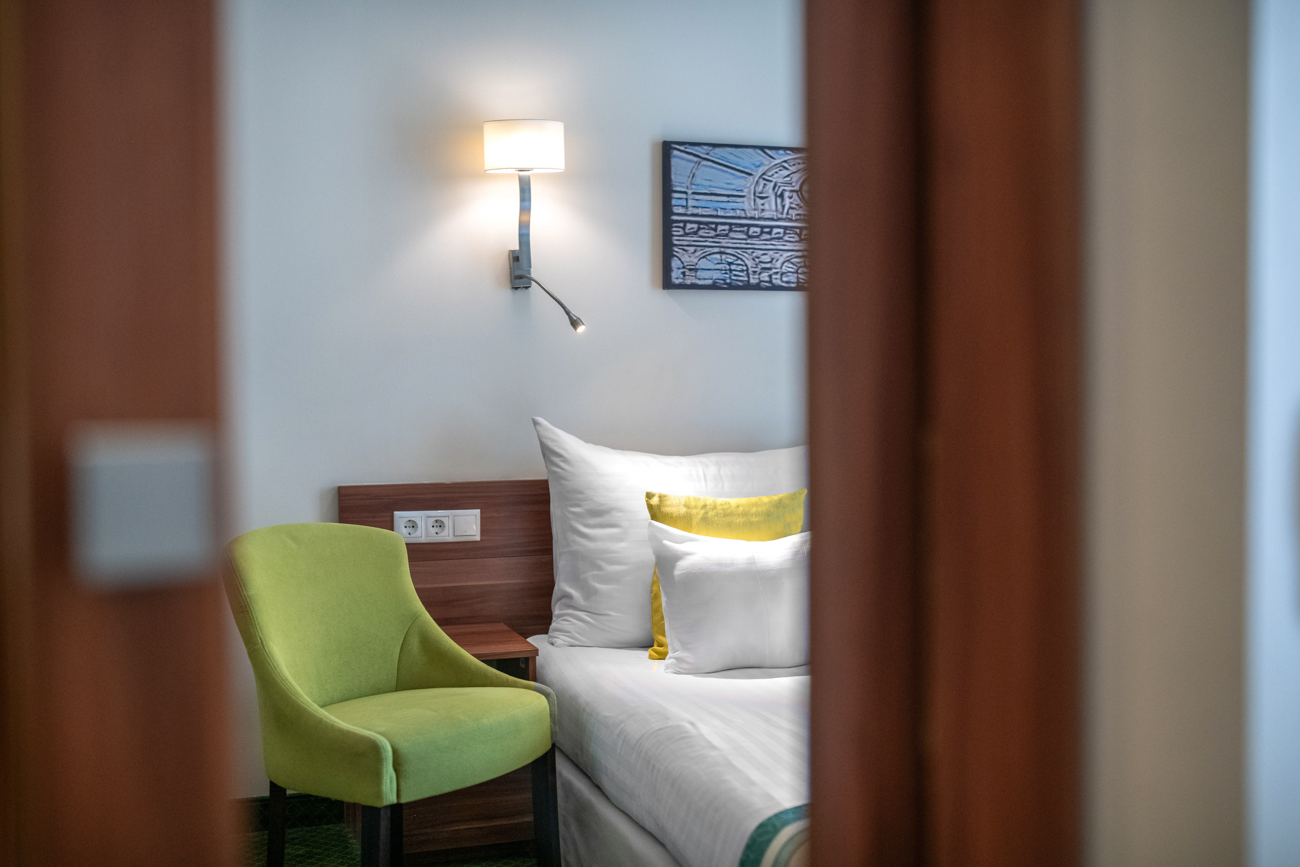 a green chair next to a bed