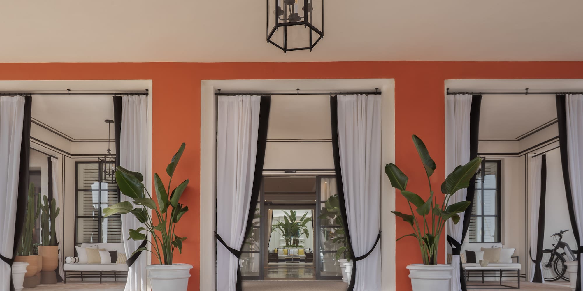 a building with white curtains and plants