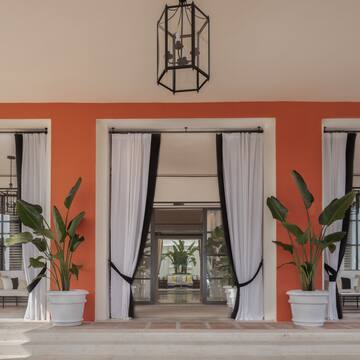 a building with white curtains and plants