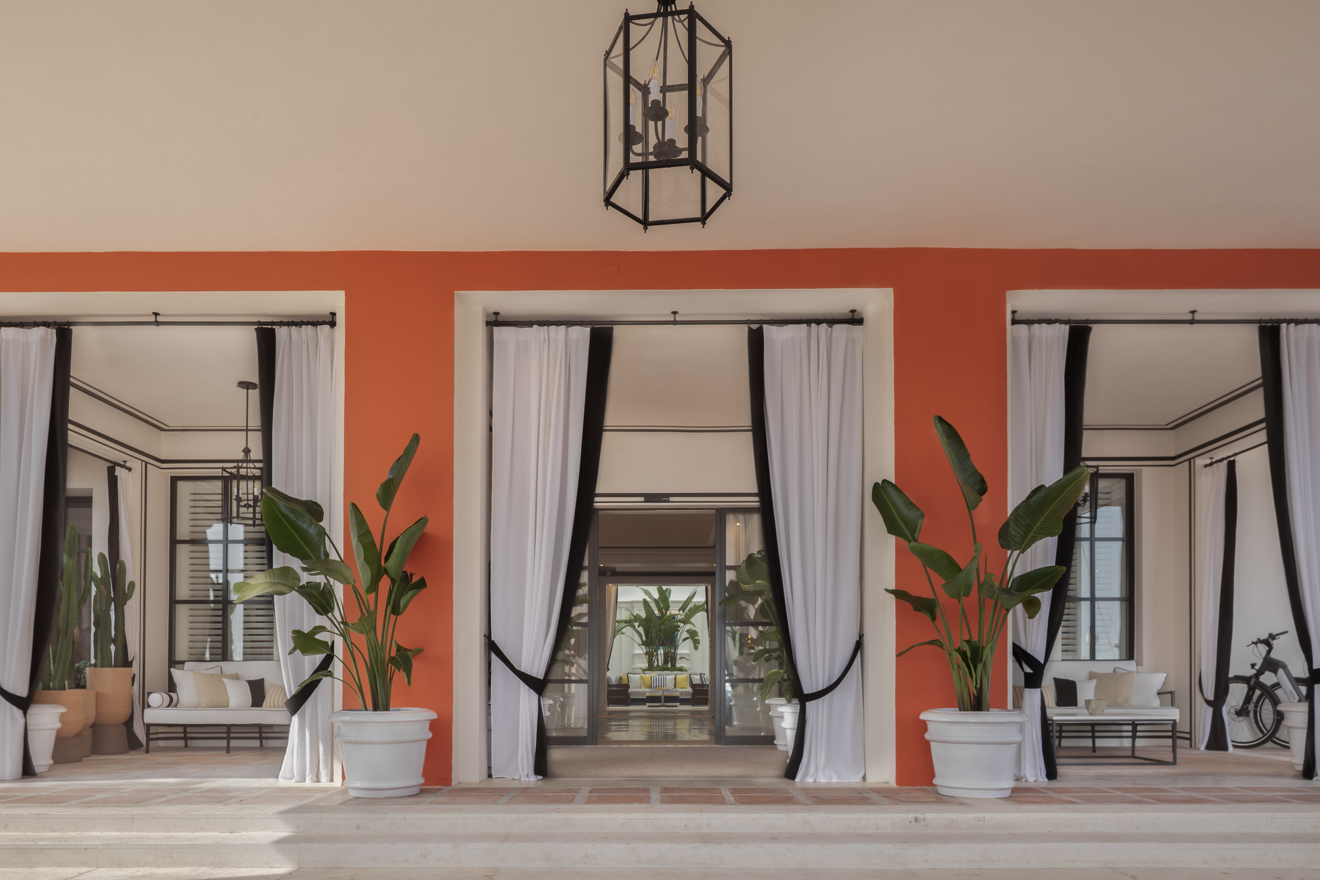 a building with white curtains and plants